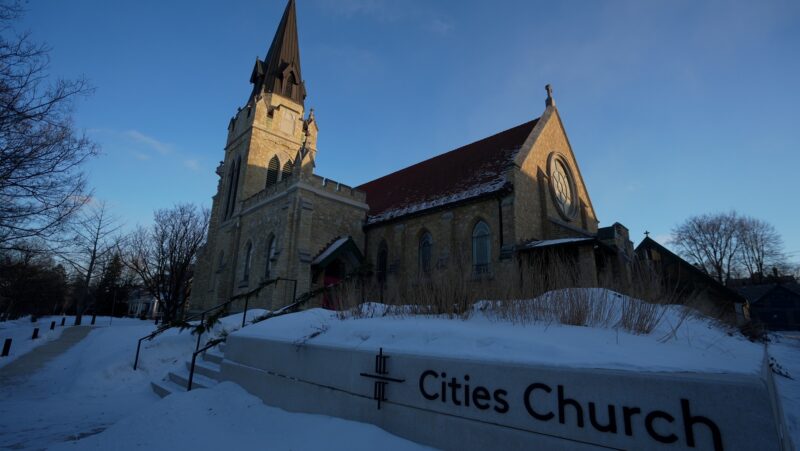 An image of the stone church surrounded by a blanket of snow, against a blue sky